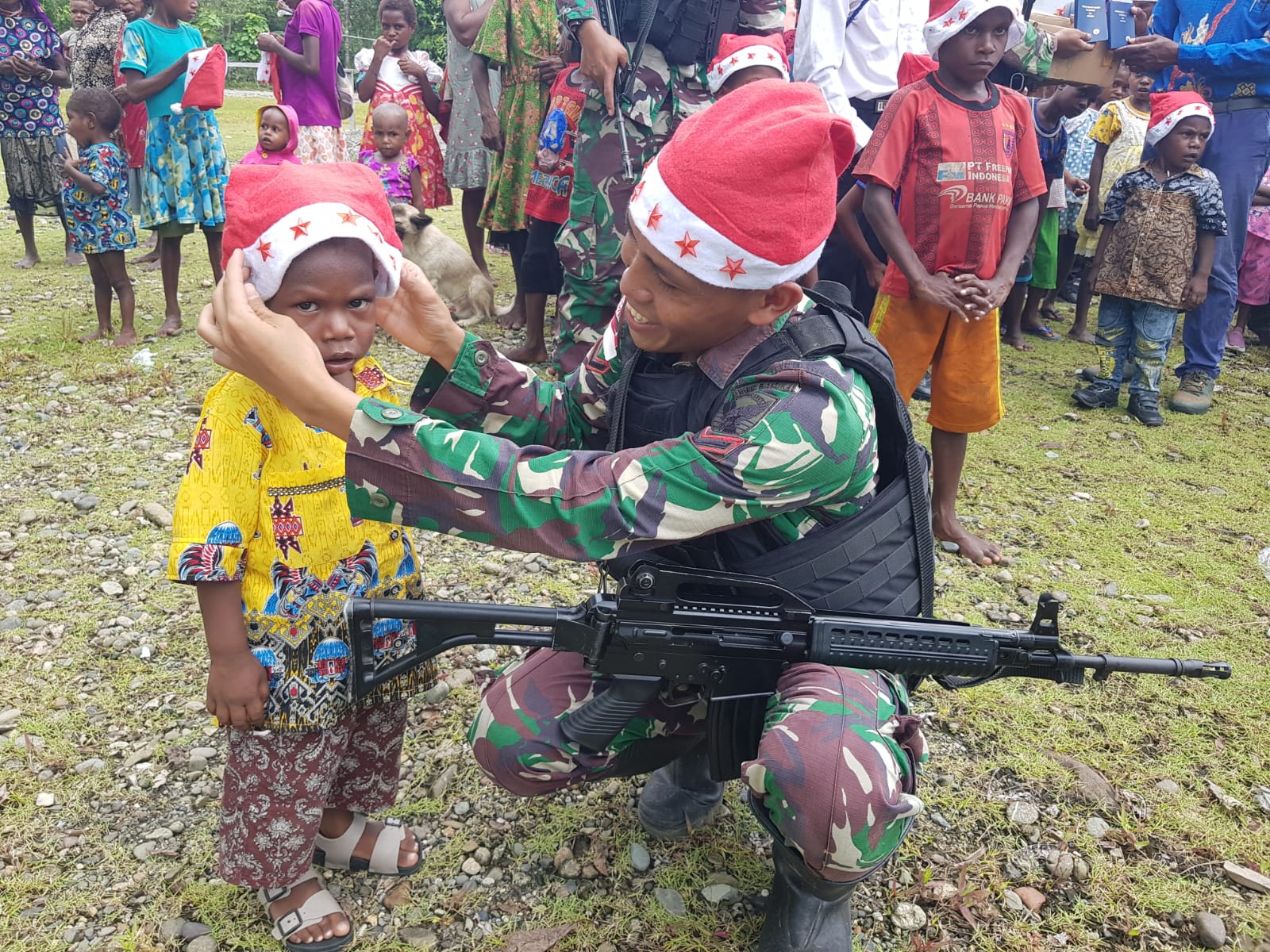 Sambut Damai Natal, Satgas Yonif Raider 142/KJ Beri Kejutan Bagikan Topi Santa dan Alkitab